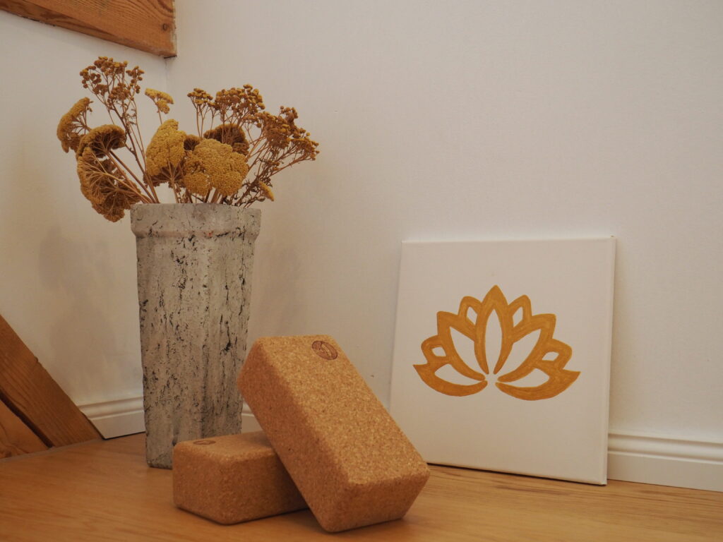 Gemütlicher Yogaraum in Vogt – Korkblöcke, Trockenblumen und ein Lotus-Bild für eine entspannte Atmosphäre bei Schwangerschaftsyoga und Frauenkreisen.